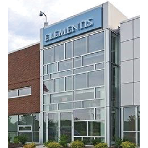 Modern building entrance with large windows and a blue sign reading 'ELEMENTIS' above.