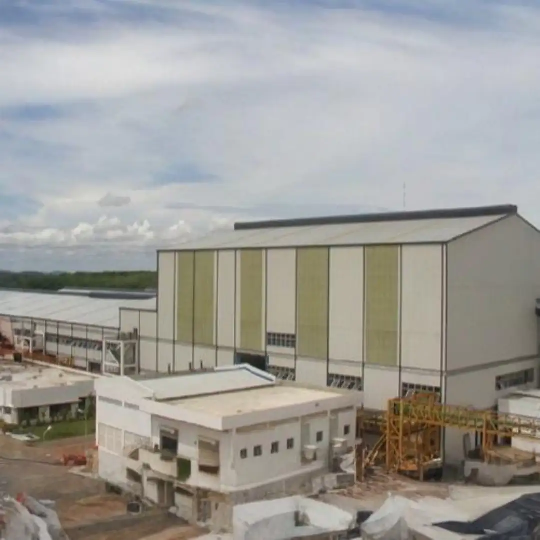 Industrial building complex with large warehouse structures under a cloudy sky.
