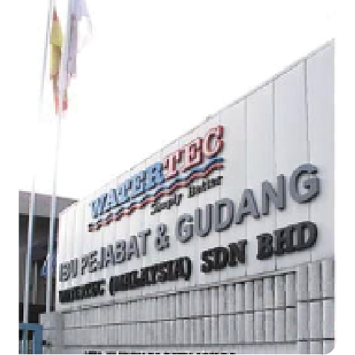 Exterior wall signage of Walibtec Sdn Bhd office and warehouse with flags on flagpoles nearby.